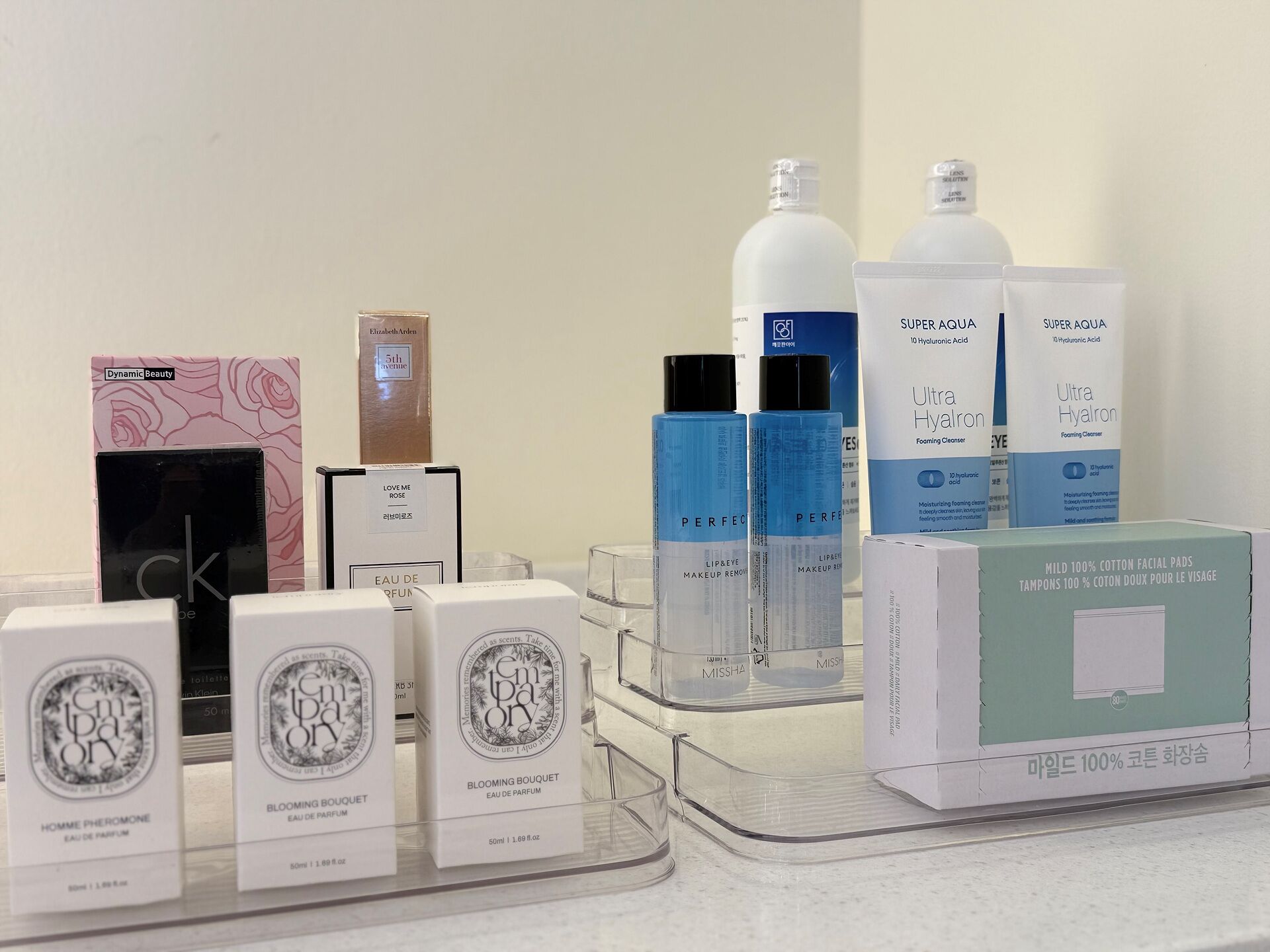 Variedad de productos para el cuidado de la piel y fragancias exhibidos en una estantería.