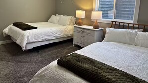 A bedroom with two beds, a nightstand, a dresser, a window with blinds, and a ceiling light. - Private 2BR retreat near Zion, Shakespeare and downtown (Cedar City)