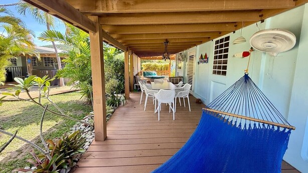 A covered patio with a hammock, white wicker chairs, and a table. - Villa 14 Flamenco Beachfront Villas (Flamenco)