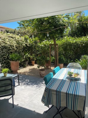 An outdoor patio with a table, chairs, potted plants, and a pergola. - House 80 m² Air-conditioned, 2 Bedrooms, 10 min. from Saint Rémy & 15 min. from Avignon (Noves)