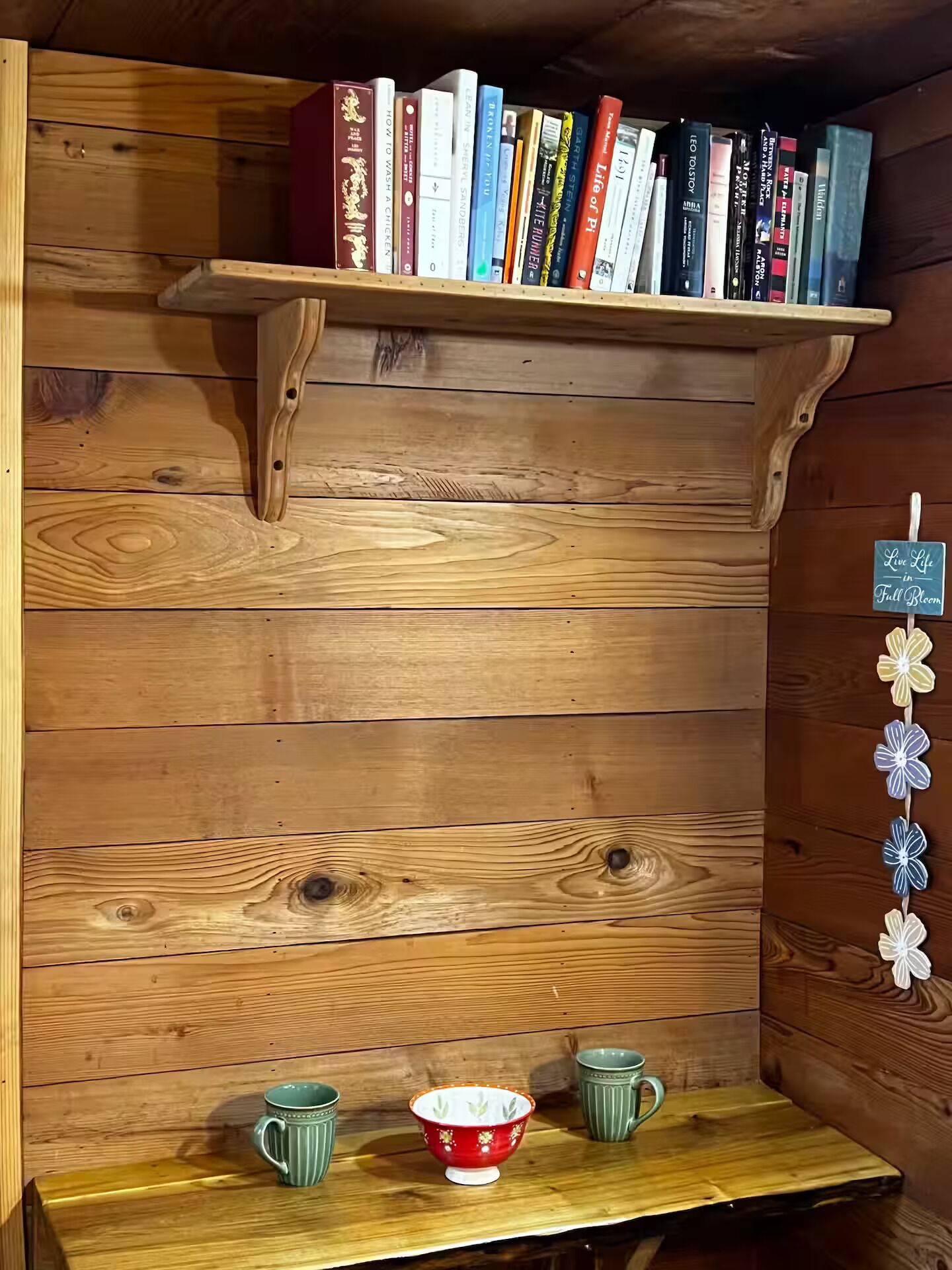 A wooden bookshelf with books and a small table with two mugs.