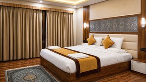 A hotel room with a large bed, wooden headboard, and a decorative wall panel. - Hotel Mustard INN Pahalgam (Anantnag)