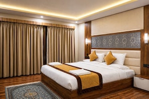 Una habitación de hotel con una cama grande, cabecera de madera y un panel decorativo en la pared.