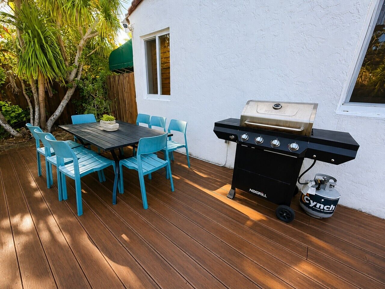 Eine Terrassenanlage im Freien mit Grill und Sitzgelegenheit.