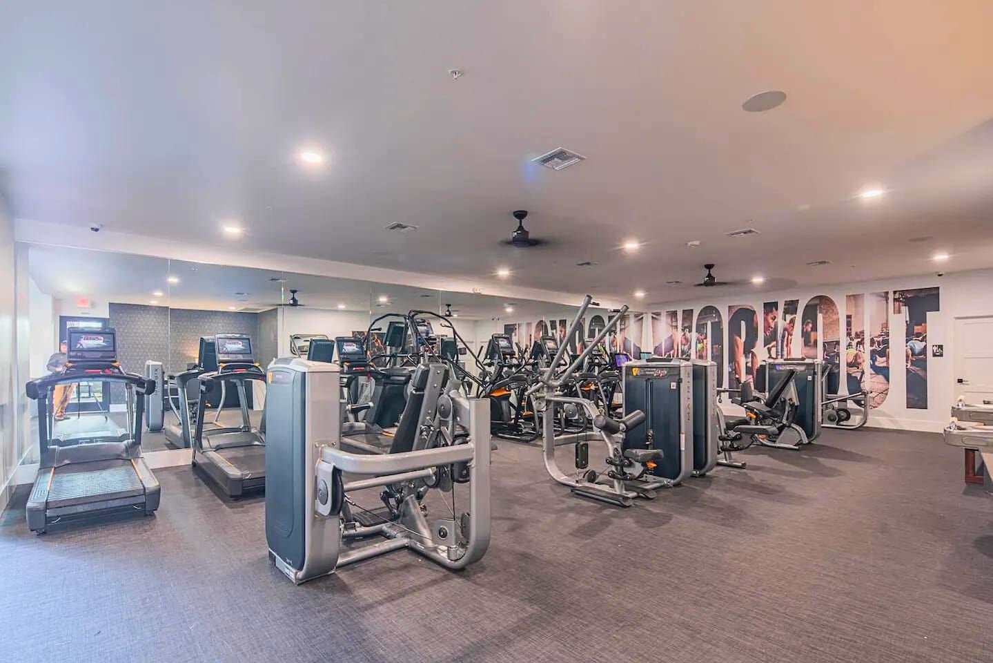 A gym with treadmills, weight machines, and exercise equipment.