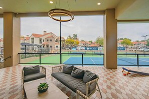 Un balcone con vista su un campo da tennis e degli edifici.