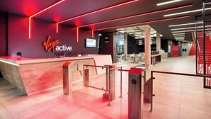 Une salle de sport Virgin Active dotée d’un comptoir d’accueil, d’équipements d’exercice et d’un aménagement intérieur moderne.