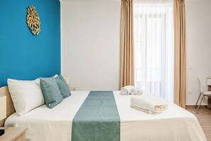 A hotel room with a bed, pillows, a blanket, a chair, and a window with curtains. - 6 minutes from Bellini Theater, 3 bedrooms with private bathroom (Catania)