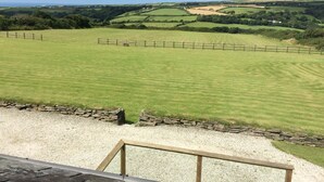 A rural landscape with a stone wall and a wooden fence. - Courtyard Farm Cottages (Boscastle)