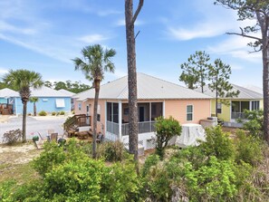 Reihenweise Strandhäuser mit überdachter Terrasse und umzäunter Veranda.
