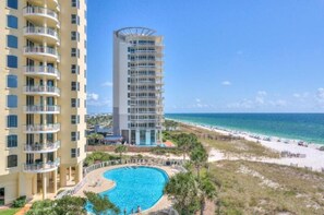 Um hotel com piscina, praia e vista para o oceano.