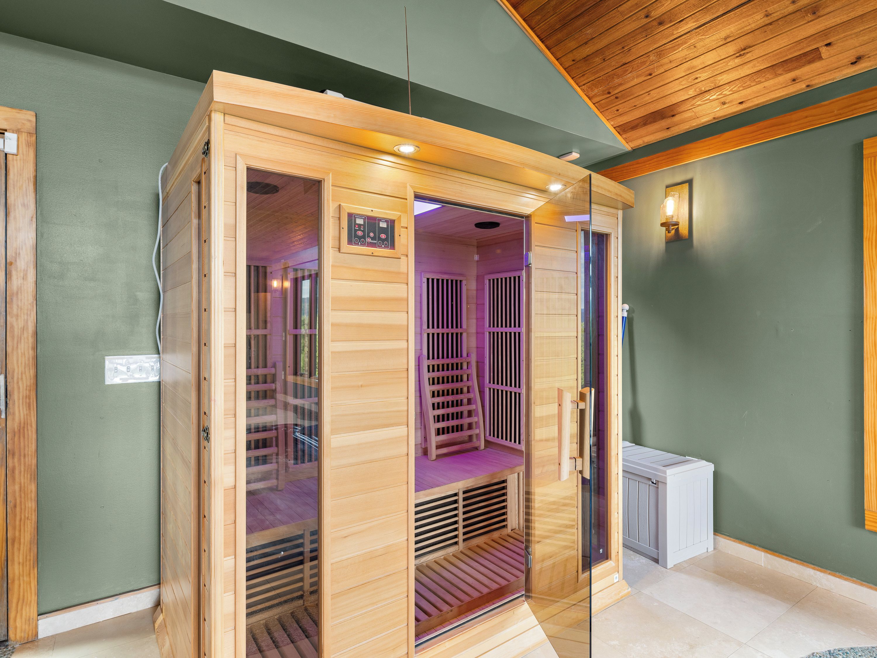 Uma sauna com exterior de madeira, portas de vidro e painel de controle.