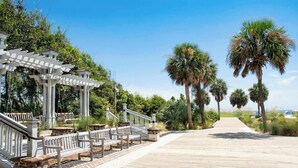 A wooden boardwalk with benches, a pergola, and palm trees. - Family Beach Retreat Near Coligny Beach (Hilton Head Island)