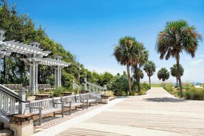 A wooden boardwalk with benches, a pergola, and palm trees. - Family Beach Retreat Near Coligny Beach (Hilton Head Island)