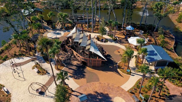 An aerial view of a park with a sandy area, a playground, and a water body. - Family Beach Retreat Near Coligny Beach (Hilton Head Island)