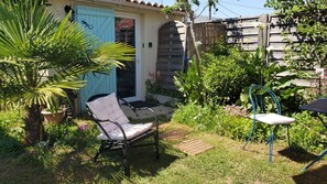A patio with a chair, a small table, and a blue door.
