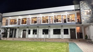 Un bâtiment moderne à deux étages, doté d’un toit plat, de grandes fenêtres et d’une pelouse bien entretenue.