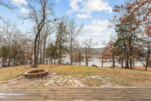 A lakeside deck with a stone fire pit and a wooden deck. - Quiet Modern Lakefront House with Amazing Views (Golden)