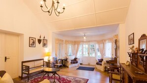 A spacious living room with a wooden coffee table, sofas, a chandelier, and a view to a dining area.