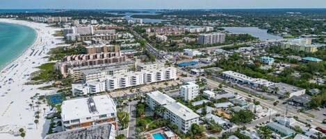 Vista aérea de una ciudad costera con playa, edificios altos y una combinación de zonas comerciales y residenciales.