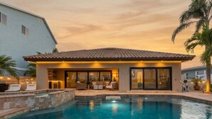 Ein modernes Haus mit Swimmingpool, großen Fenstern und einer Terrassenanlage.