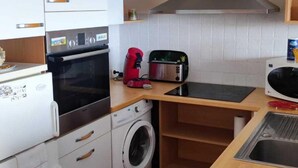 A compact kitchen with a washing machine, a toaster, and a microwave. - Grand studio Résidence les 3 Iles Quiberon N°28 (Quiberon)