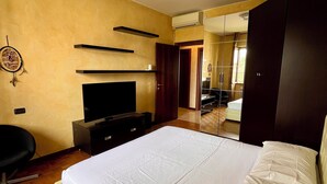 A bedroom with a bed, a TV, a desk, and a wardrobe. - Spacious Living with Balcony near Fondazione P... (Milan)