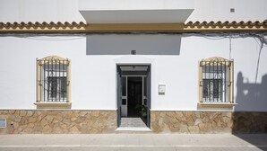 A building with a stone base, a tiled roof, and two barred windows. - Holiday Home 'En La Gloria' – Accessible, Central Location Near the Beach (Barbate)