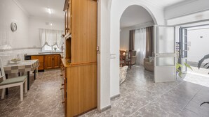 A modern kitchen with wooden cabinets, a dining area with a checkered tablecloth, and a living room with a sofa and a coffee table. - Holiday Home 'En La Gloria' – Accessible, Central Location Near the Beach (Barbate)