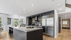 A modern kitchen with a central island, stainless steel appliances, and a contemporary design. - Village Luxe | Ski-in/Ski-out | Heated Pool & Spa (Beaver Creek)