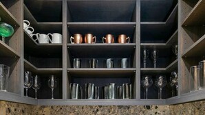 A kitchen with a granite countertop, a built-in wine rack, and a variety of kitchenware. - Village Luxe | Ski-in/Ski-out | Heated Pool & Spa (Beaver Creek)