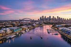 A waterfront cityscape with a prominent bridge, marina, and modern buildings. - The Surry Studio Cosy Stay near Cafs and Nightlife (Surry Hills)
