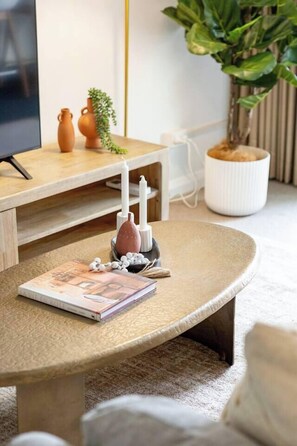 Ein runder Tisch mit einem Buch, Kerzen und einem Diffusor.