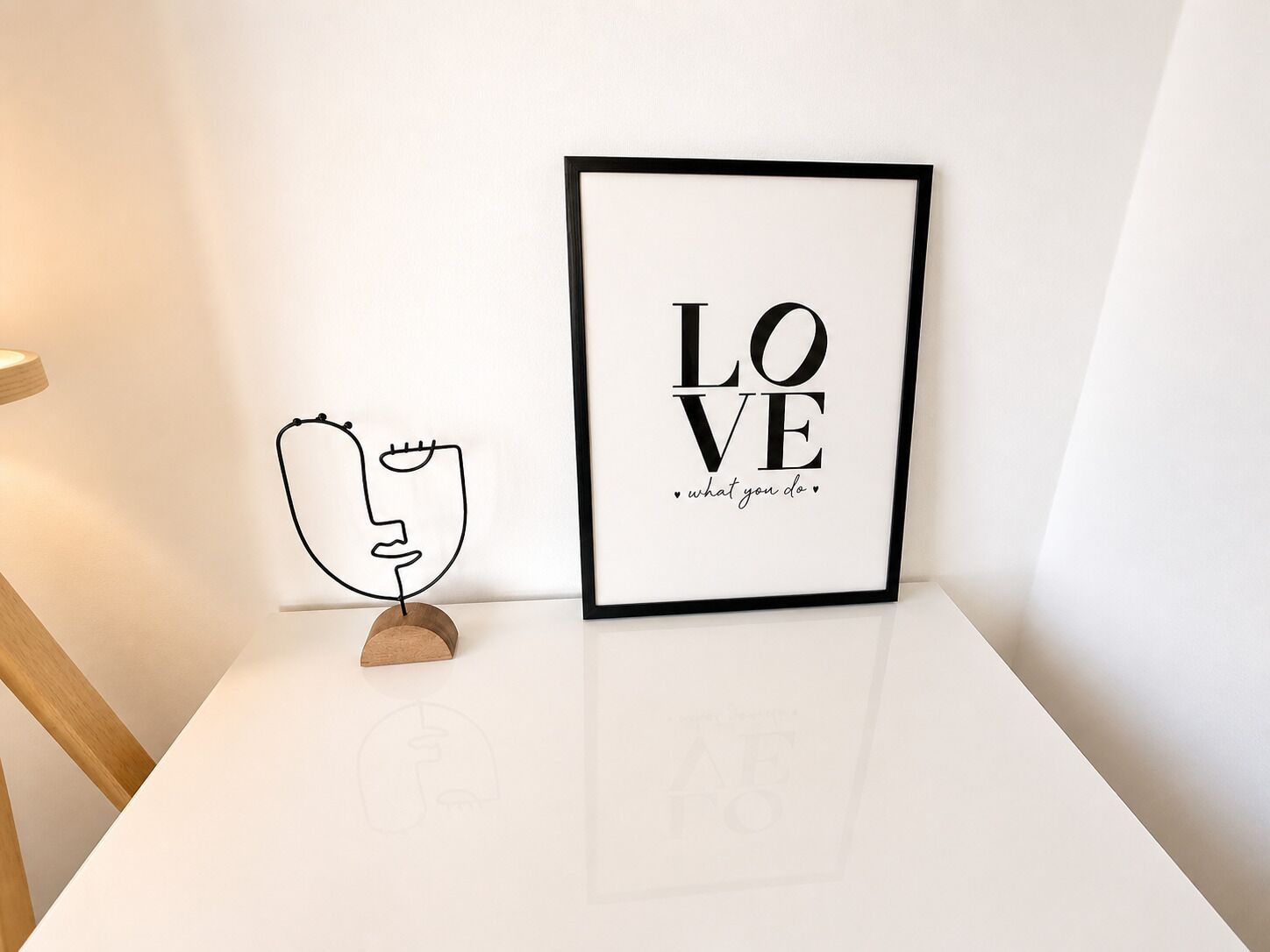 A framed artwork with the words 'LOVE what you do' on a white wall.