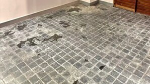A room with a tiled floor, a wooden door, and a small window.