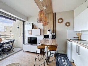 Eine moderne Küche mit einer Holzinsel, Barhocker, einer Mikrowelle und einer Kaffeemaschine.