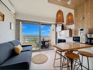 Eine moderne Wohnung mit Balkon, Essbereich und Küchenzeile.