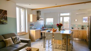 Een moderne keuken met een eethoek, een bank en een kleine tafel met een kom.