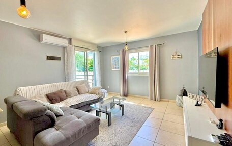 A modern living room with a sofa, coffee table, and a flat-screen TV.