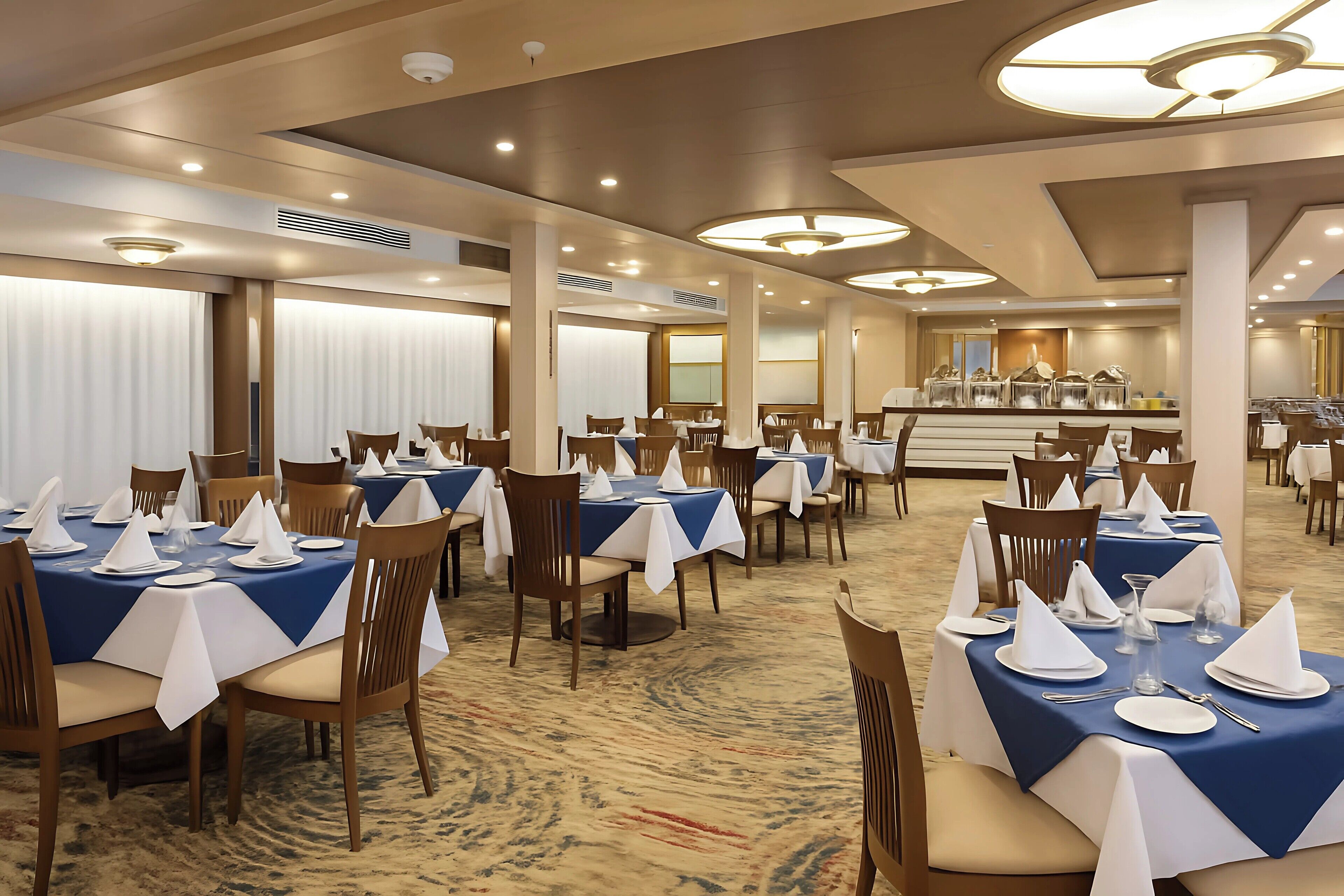 En hotellrestaurang med bord som är dukade och redo för servering, med en central buffé och en stor kristallkrona.