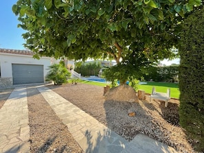 A landscaped garden with a pathway, a bench, and a tree. - Soothing villa 300 metres from the beach (Les Tres Cales)