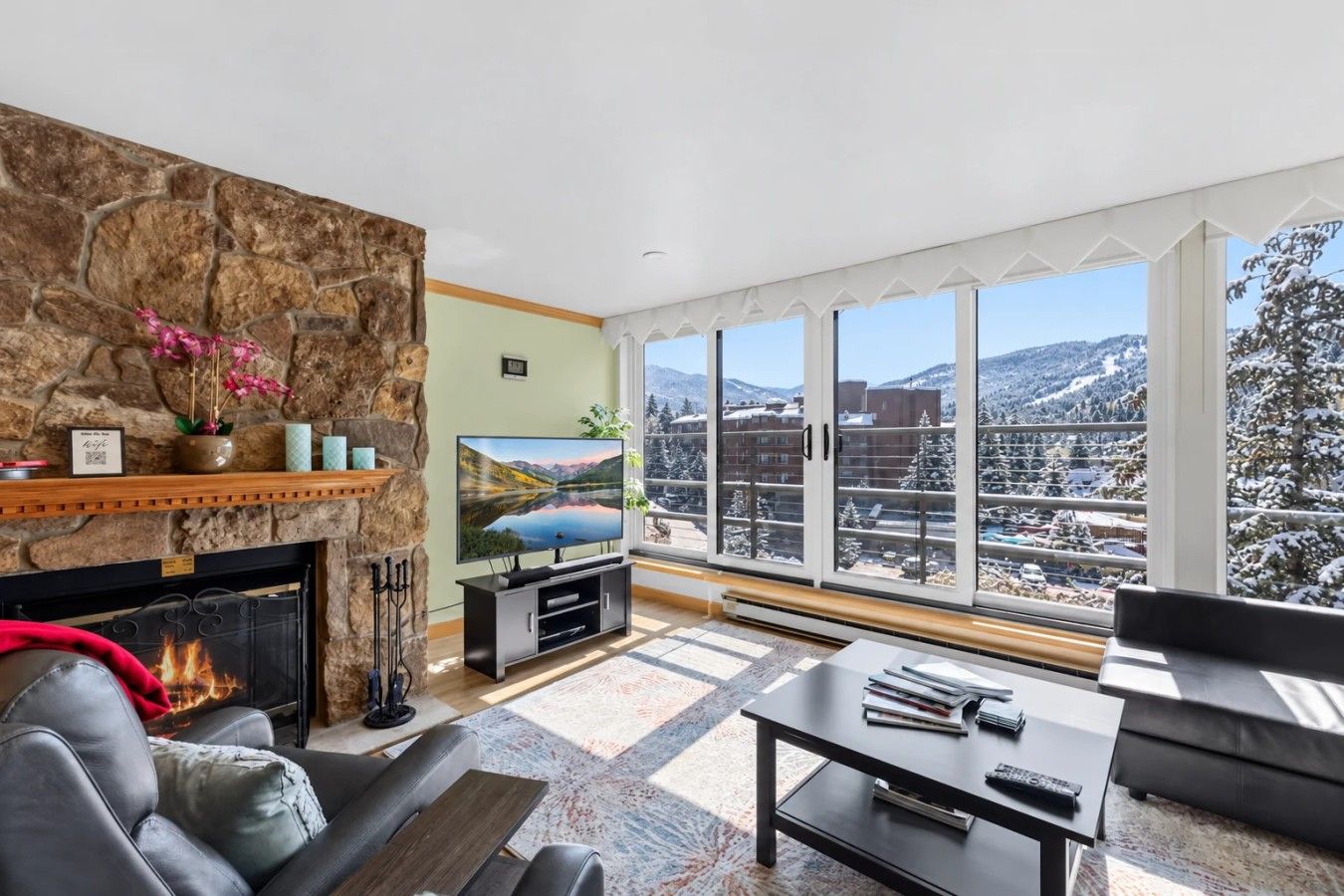 Living room with cozy seating, wood burning fireplace, smart TV, and mountain views