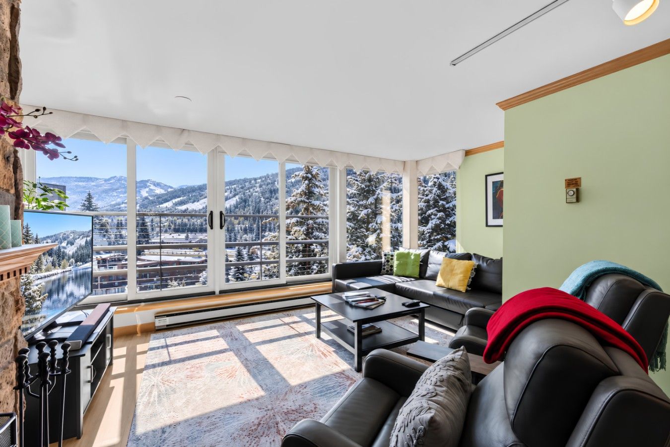 Living room with cozy seating, wood burning fireplace, smart TV, and mountain views
