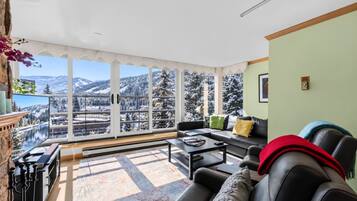 Living room with cozy seating, wood burning fireplace, smart TV, and mountain views