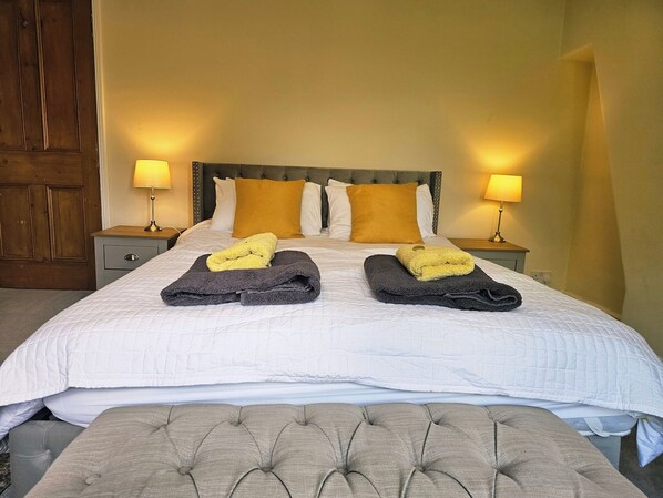 A hotel room with a bed, two nightstands, a wooden door, and a large window. - Save 25% OFF Monthly| Sharrow Retreat | Sleeps 4 (North Yorkshire)