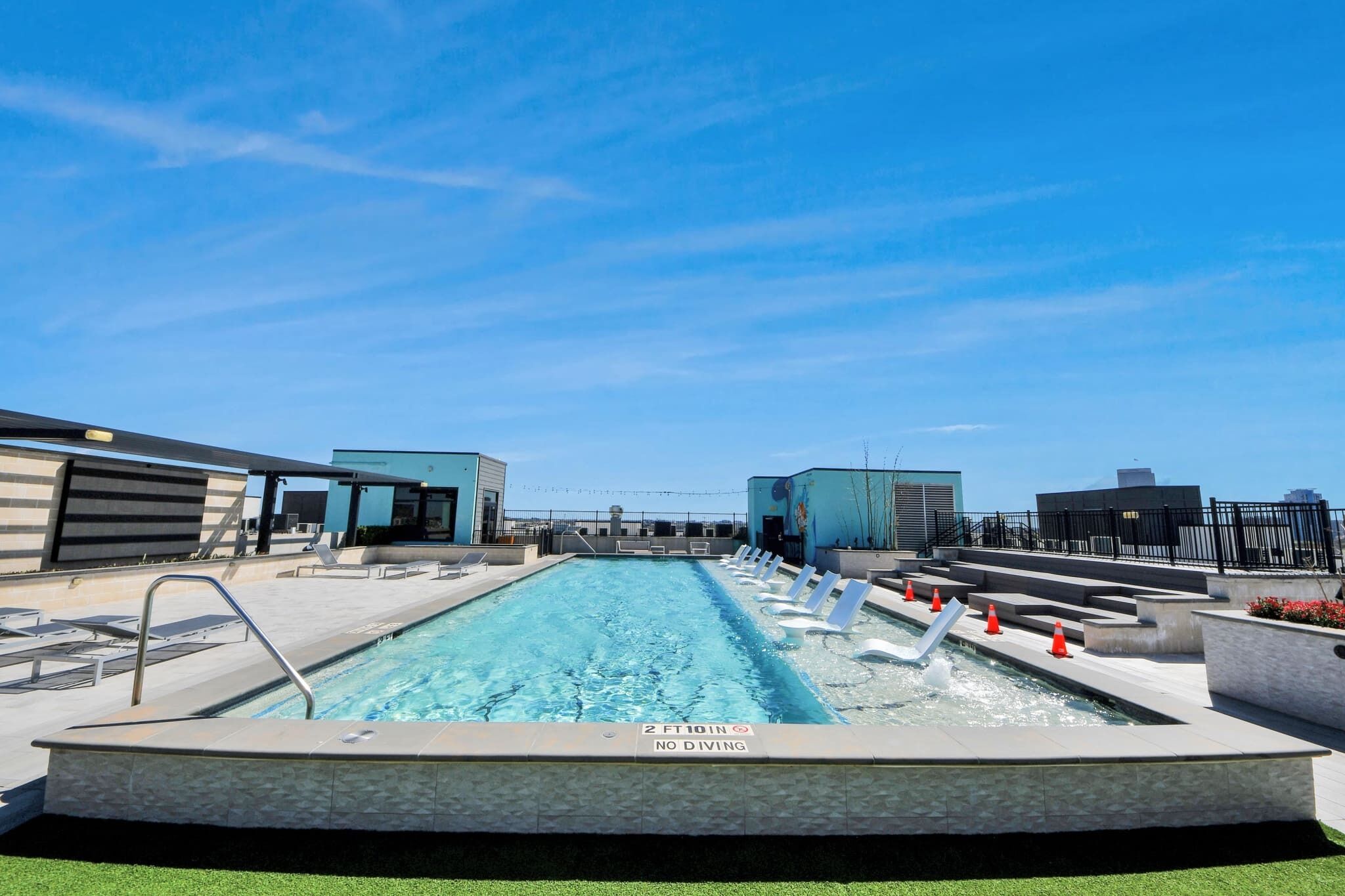 Une piscine sur le toit, avec une profondeur maximale de 2 pieds 10 pouces et un panneau indiquant qu’il est interdit de plonger.