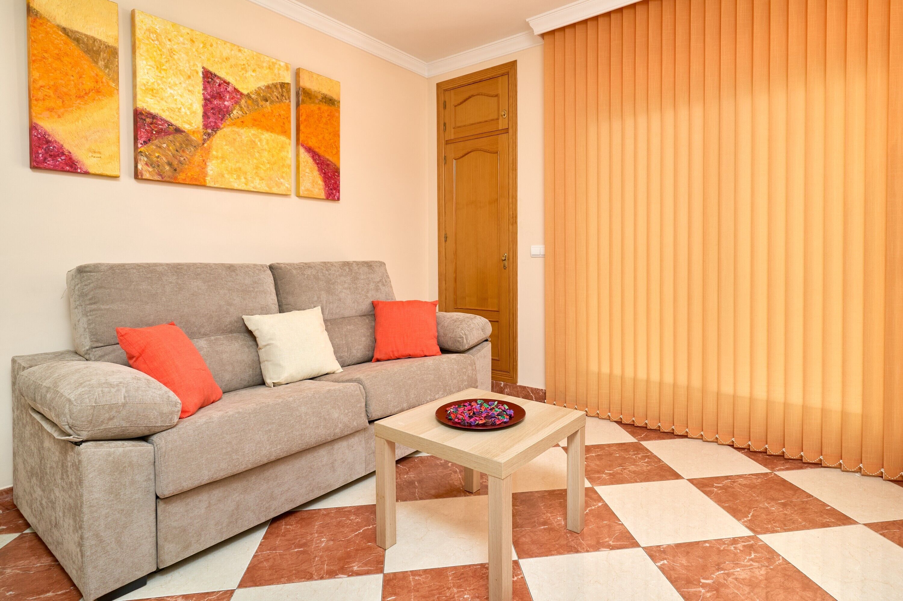 A living room with a sofa, a small table, and a door.