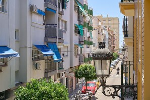 A narrow street with multi-story buildings, balconies, and parked cars. - Apartment 'Pilar Torre Del Mar' with Wi-Fi and Air Conditioning (Torre del Mar)