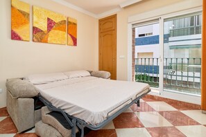 A room with a bed, a sliding glass door to a balcony, and abstract wall art. - Apartment 'Pilar Torre Del Mar' with Wi-Fi and Air Conditioning (Torre del Mar)