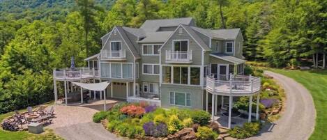 A two-story house with a covered porch and a landscaped garden.